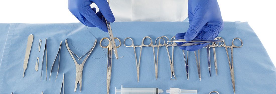 Surgeon in medical gloves holding some surgical instrument in an operating room.